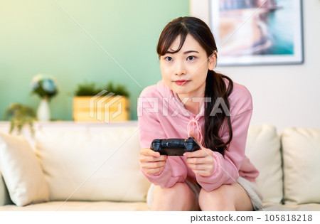 Young woman playing online games noon 105818218