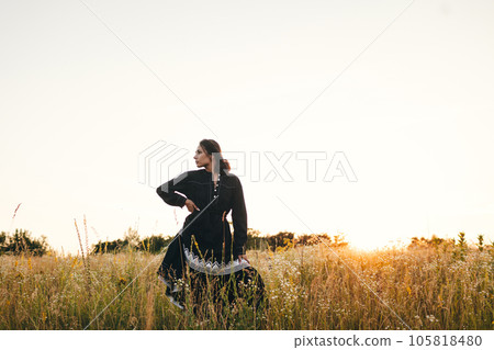 Portrait of woman in golden sunset light in outdoor meadow. Springtime and summer lifestyle. Wellbeing and zen like meditation activity in outdoor. Loving life Portrait of woman in golden sunset light in outdoor meadow. Springtime and summer lifestyle. Wellbeing and zen like meditation activity in outdoor. Loving life 105818480