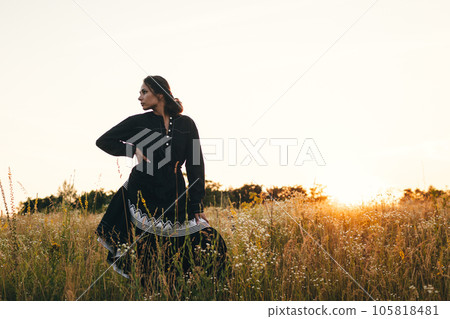 Portrait of woman in golden sunset light in outdoor meadow. Springtime and summer lifestyle. Wellbeing and zen like meditation activity in outdoor. Loving life 105818481