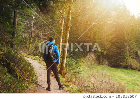 A guy tourist with a backpack stands on a mountain trail and looks into the distance. The concept of travel and adventure. Traveler Man with backpack mountaineering Travel Lifestyle concept mountains 105818607
