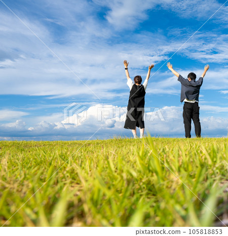 A man and a woman walking in a wide meadow 105818853