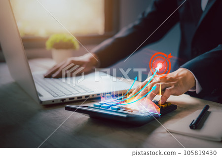 Investment growing according to the goal. income tax paid, dividend, interest rate and corporations. Businessman calculating with calculator, laptop (notebook) of return on financial research, report Investment growing according to the goal. income tax paid, dividend, interest rate and corporations. Businessman calculating with calculator, laptop (notebook) of return on financial research, report 105819430