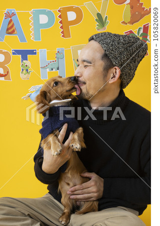 Man celebrating his dog's birthday 105820069
