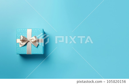 Blue gift box with satin ribbon on blue background. Top view of birthday gift with space for text. High quality photo 105820156