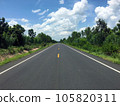 Image of new paved road in the daytime in the countryside painted yellow dividing line with trees, grass along the road, sky with white clouds 105820311