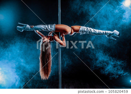 Young woman pole dancing on dark background with blue smoke 105820459