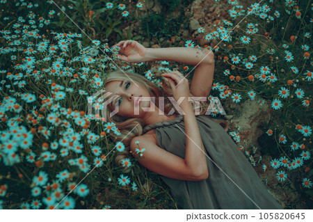 Young woman portrait on summer field with chamomiles Young woman portrait on summer field with chamomiles 105820645