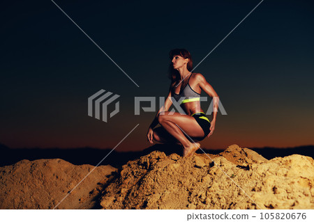 Young slim sports woman at the top of mountain, dark vibrant twilight colors Young slim sports woman at the top of mountain, dark vibrant twilight colors 105820676