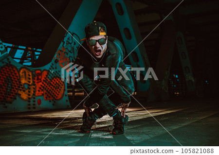 Young cool man break dancer posing on urban bridge at night 105821088