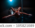 Young woman pole dancer posing in water with blue light 105821089