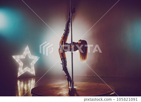 Young sexy woman in black lingerie pole dancing in dark interior 105821091