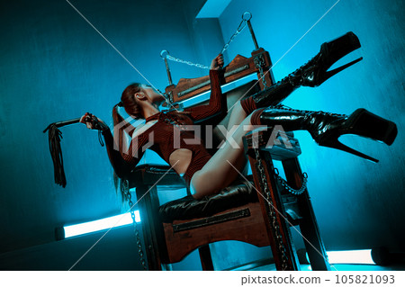 Young slim asian woman bdsm style portrait in chair 105821093