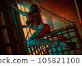 Young woman dancer posing in hall with metallic cage 105821100
