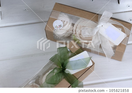 Homemade marshmallows in paper gift boxes. Zephyr flowers. The boxes are tied with a ribbon tied into a bow. Tag for text. 105821858