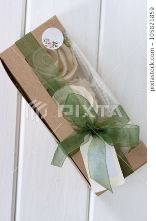 Homemade marshmallows in paper gift box. Zephyr flowers. The box are tied with a ribbon tied into a bow. Tag for text. Homemade marshmallows in paper gift box. Zephyr flowers. The box are tied with a ribbon tied into a bow. Tag for text. 105821859