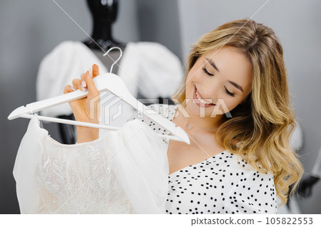 Young beautiful woman chooses a dress for wedding in a wedding salon 105822553