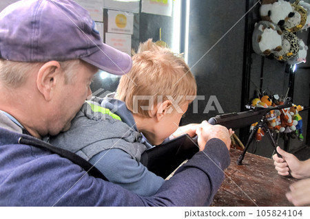 Dad teaches his son to shoot at shooting range 105824104