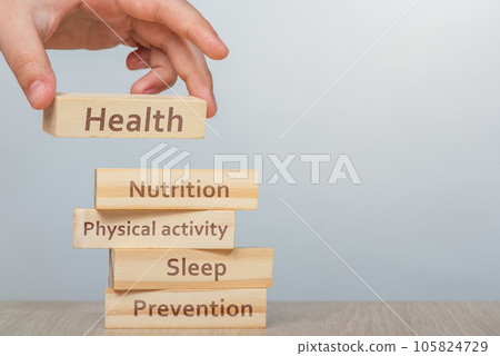 Health concept. The hand lays wooden rectangles on top of each other. Cubes with inscriptions, Physical activity, Nutrition, Sleep and Prevention on them, uniting the word HEALTH close-up. Health concept. The hand lays wooden rectangles on top of each other. Cubes with inscriptions, Physical activity, Nutrition, Sleep and Prevention on them, uniting the word HEALTH close-up. 105824729