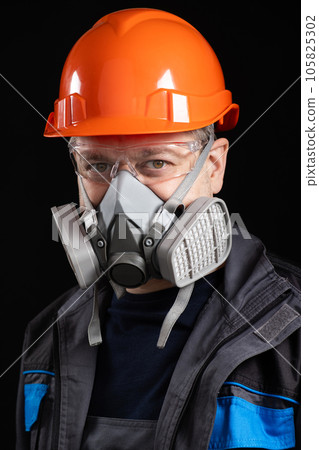 A man wearing a helmet, respirator and goggles on a black background A man wearing a helmet, respirator and goggles on a black background 105825302