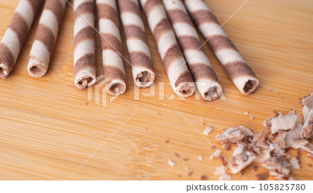 Group of crunchy beige hazelnut rolled wafer on the wooden surface. flat lay . close-up 105825780