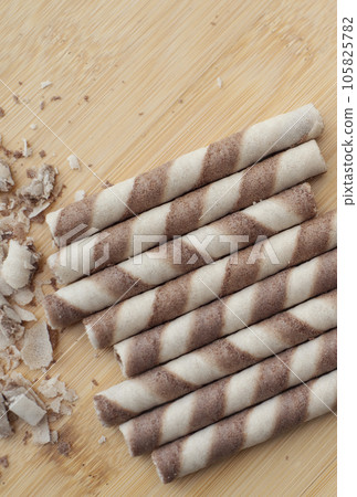 Group of crunchy beige hazelnut rolled wafer on the wooden surface. flat lay . close-up Group of crunchy beige hazelnut rolled wafer on the wooden surface. flat lay . close-up 105825782