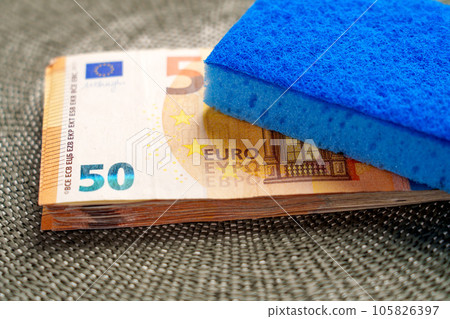 Money laundering concept. A sponge is placed on a stack of euro banknotes close up Money laundering concept. A sponge is placed on a stack of euro banknotes close up 105826397