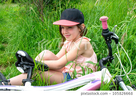 a child girl has damaged a bicycle wheel and is making repairs photo without processing. High quality photo 105826668