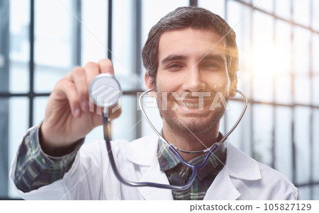 cardiologist smiling confidently and showing his stethoscope. Concept of medicine, hospitals and doctors, care 105827129
