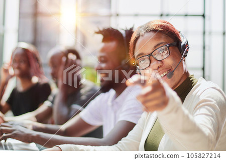 Smiling beautiful African American woman working in call center with diverse team 105827214
