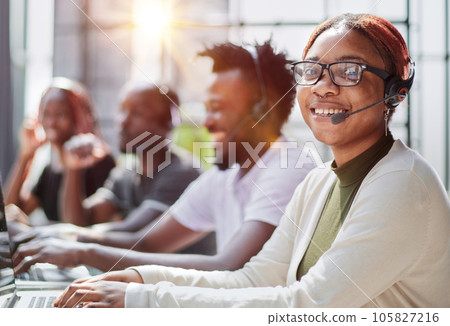 Smiling beautiful African American woman working in call center with diverse team 105827216