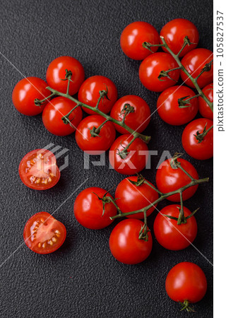Delicious fresh cherry tomatoes on the branches as an ingredient for cooking a vegetarian dish 105827537