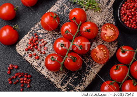 Delicious fresh cherry tomatoes on the branches as an ingredient for cooking a vegetarian dish 105827548
