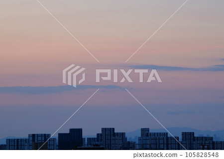 黎明在城市。東方的天空變亮了，雲升之前的太陽呈現出美麗的漸變。神戶市 105828548
