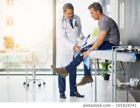 Doctors do it for the health of it. Shot of a mature doctor examining his patient who is concerned about his knee. 105828741