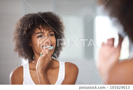 Reflection, health and black woman brushing teeth, cosmetics and oral health at home. Female person, model and girl cleaning her mouth, mirror and dental hygiene with fresh breath, wellness and care 105829013