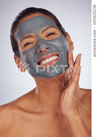 Happy woman, charcoal mask and portrait for beauty, aesthetic dermatology and self care on studio background. Mature female model touch face with clay skincare product, facial cosmetics and smile Happy woman, charcoal mask and portrait for beauty, aesthetic dermatology and self care on studio background. Mature female model touch face with clay skincare product, facial cosmetics and smile 105829156
