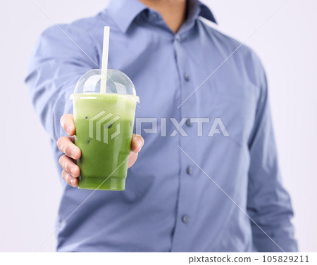 Smoothie drink in man hands isolated on white background for diet, detox and healthy breakfast offer. Person or nutritionist hand holding or giving green juice for healthy or vegan protein in studio 105829211