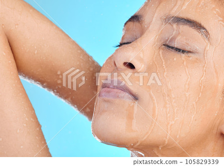 Shower water, face and black woman cleaning body with liquid for hydration, beauty healthcare or skincare hygiene. Self care studio, spa salon girl and relax model washing isolated on blue background Shower water, face and black woman cleaning body with liquid for hydration, beauty healthcare or skincare hygiene. Self care studio, spa salon girl and relax model washing isolated on blue background 105829339