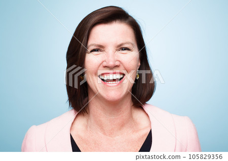 Happy, portrait of mature woman smile and against a blue background for health wellness. Happiness, mock up space and excited or cheerful female person smiling with pose against a studio backdrop Happy, portrait of mature woman smile and against a blue background for health wellness. Happiness, mock up space and excited or cheerful female person smiling with pose against a studio backdrop 105829356