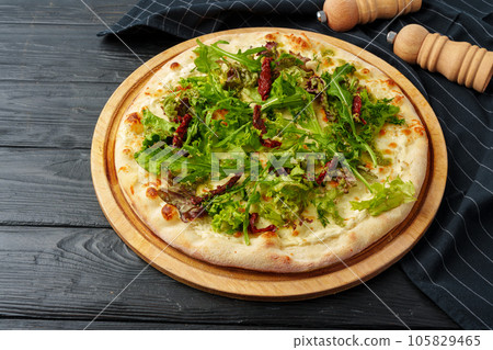Fresh tasty pizza on black wooden background Fresh tasty pizza on black wooden background 105829465