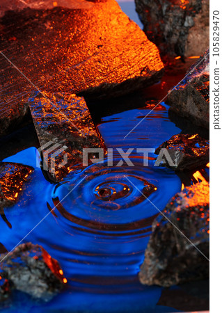 Stones and water illuminated by colored light Stones and water illuminated by colored light 105829470
