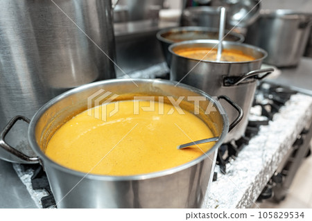 Food preparing in metal pots on the stove at professional kitchen Food preparing in metal pots on the stove at professional kitchen 105829534