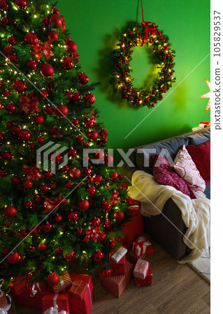 Christmas living room interior with sofa, Christmas tree and wreath on green background Christmas living room interior with sofa, Christmas tree and wreath on green background 105829537