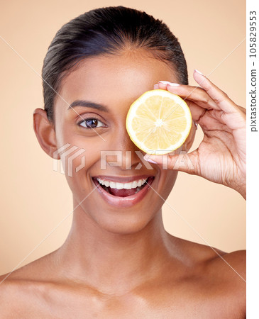 Lemon, beauty and portrait of happy woman in studio for vitamin c nutrition, spa or natural cosmetics. Face of indian female model, healthy skincare or citrus fruit in dermatology, vegan diet or glow 105829553