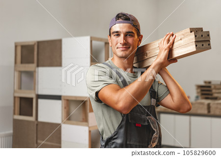 Portrait of young male carpenter standing in the wood workshop Portrait of young male carpenter standing in the wood workshop 105829600