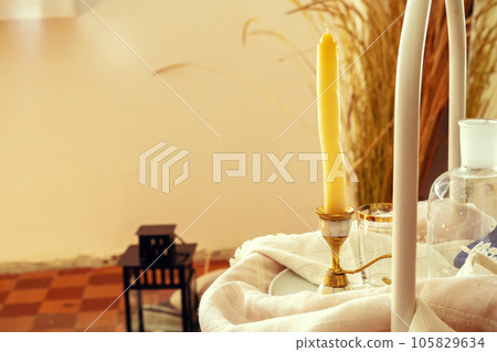 Golden candlestick and glass on the table 105829634