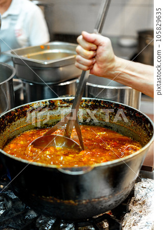 Chef cooking food at restaurant kitchen close up Chef cooking food at restaurant kitchen close up 105829635