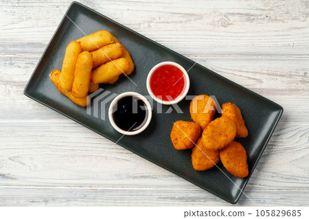 Fried snacks platter with sauce on gray wooden table 105829685