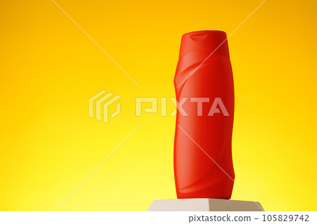 Cosmetic bottle with sunscreen lotion on yellow background 105829742