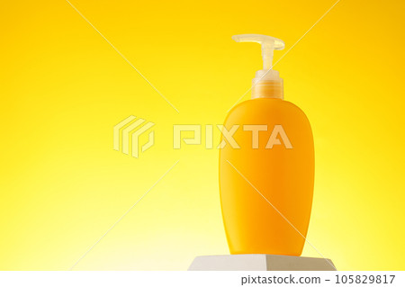 Cosmetic bottle with sunscreen lotion on yellow background Cosmetic bottle with sunscreen lotion on yellow background 105829817